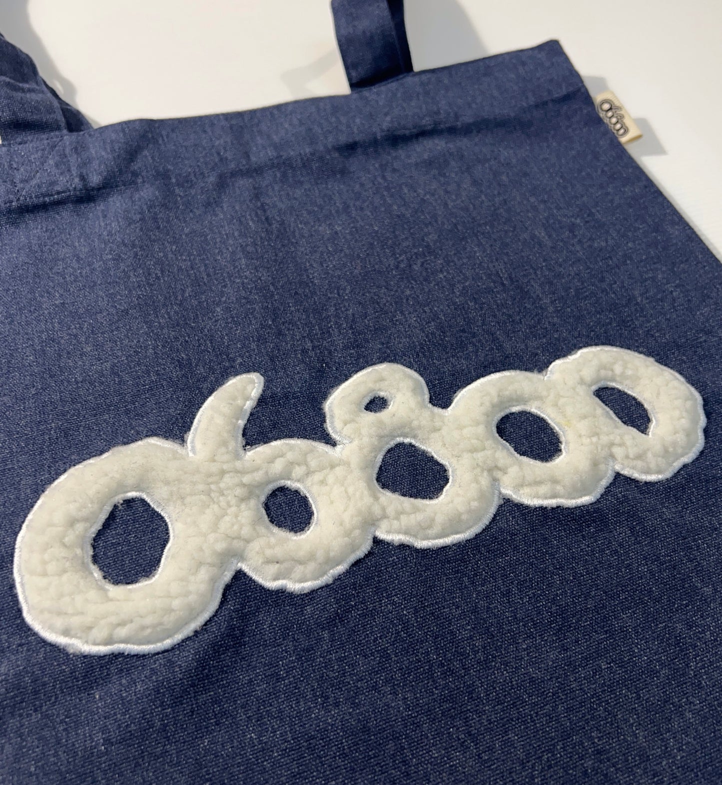 TOTE BAG DENIM CON TELA DE BORREGUITO CRUDO BORDADO