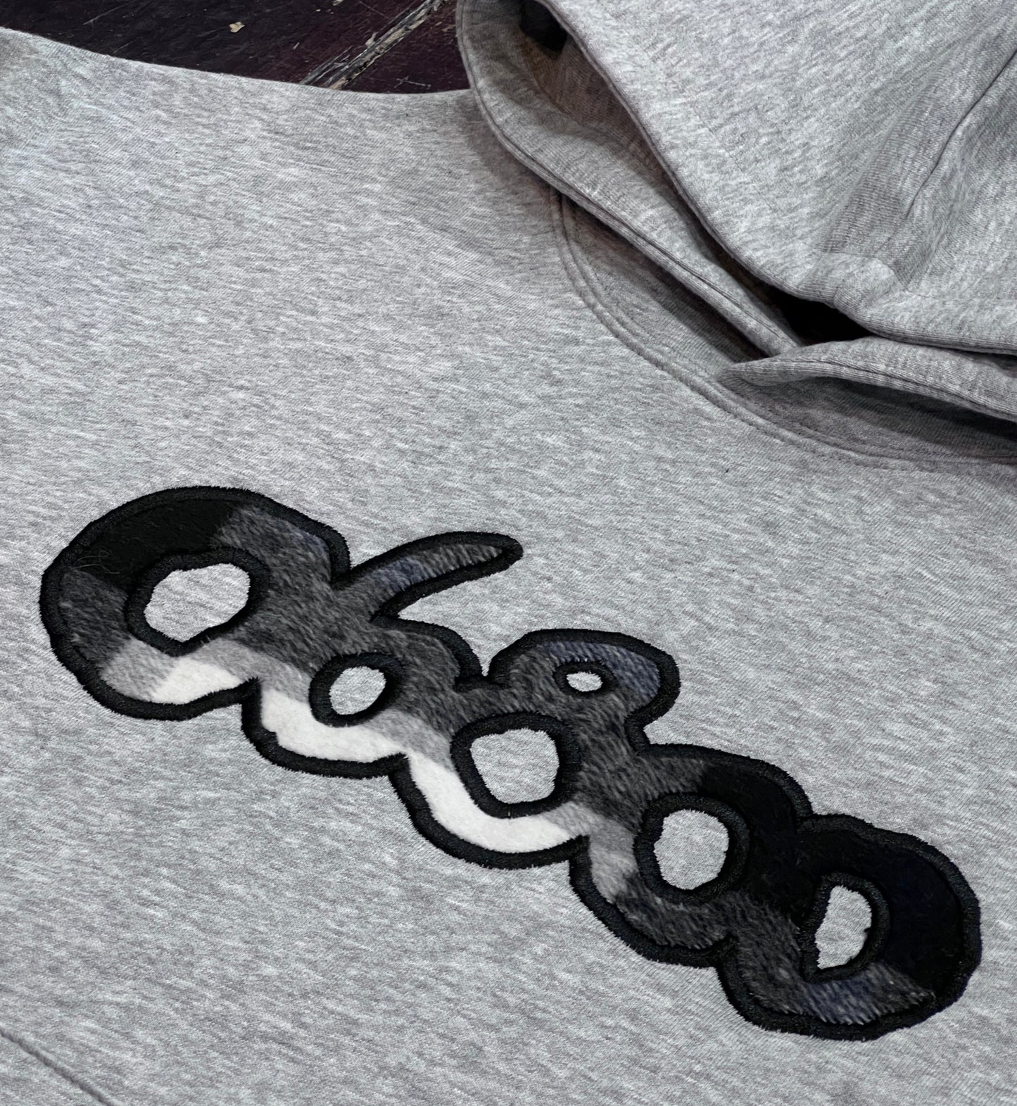 SUDADERA GRIS CON TELA A CUADROS BLANCO Y NEGRO BORDADO