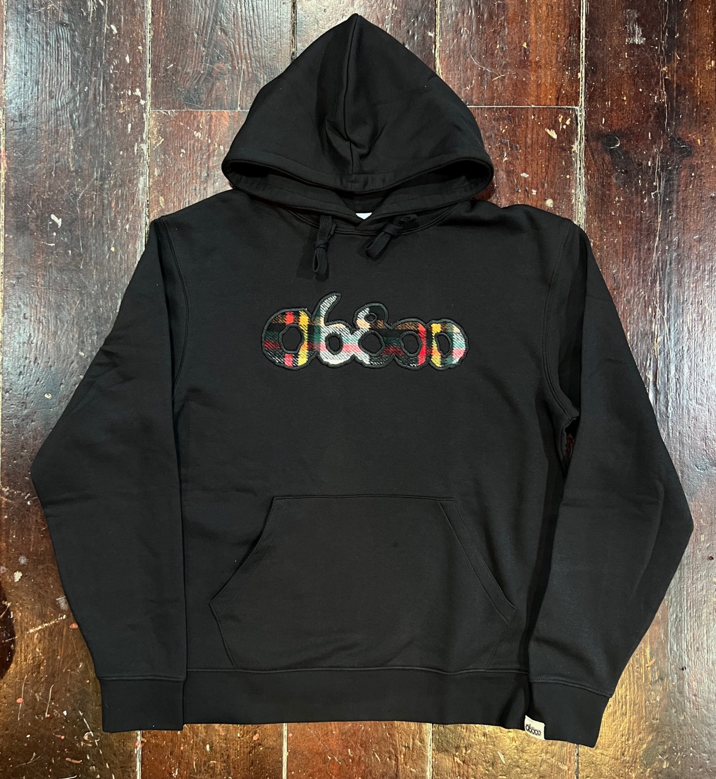 SUDADERA NEGRA CON TELA A CUADROS Y BORDADO